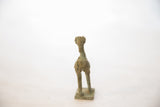 A view from behind the oxidized bronze stork, showing its stylized body, slender legs, and square stand.