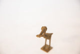 A detailed view of the vintage bronze stork's head holding a fish.
