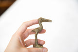 Vintage African bronze stork held in hand to demonstrate its scale and texture.
