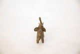 Rear view of a small handmade African bronze elephant showing its textured patina.