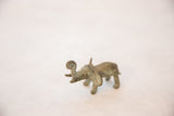 Angled view of a collectible bronze elephant showing its rustic patina and spiraled trunk.