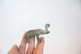 A small vintage bronze elephant with curled trunk held in hand for scale.