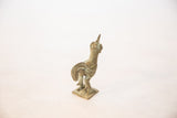 Low-angle detail of a vintage bronze rooster's ribbed neck and upturned head.