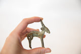 Small handmade bronze impala sculpture with an aged patina held to show scale.