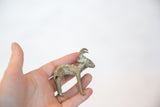 Small vintage bronze antelope figurine held in hand to show its collectible scale.