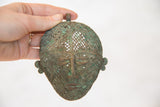 Decorative loop and upper section of a vintage African copper head with green patina.