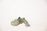 Side profile of the vintage copper fish showing its curved body and textured green patina.