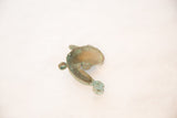 Angled view of the vintage copper fish pendant, showing its curved body and trefoil tail.