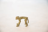 The arched posture and oxidized bronze texture of a vintage monkey sculpture.