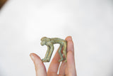 Vintage African oxidized bronze monkey figure, textured green-brown patina.