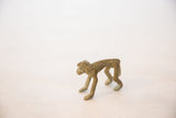 Profile view of the vintage bronze monkey highlighting its textured, oxidized finish.