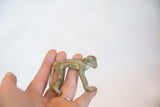 Handmade vintage bronze monkey held in a palm to show its small size and oxidized patina.