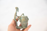 Vintage African copper drummer held in hand, showing its profile and scale.