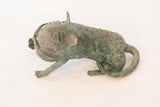 Three-quarter view of a vintage copper feline showing its textured, oxidized green patina.
