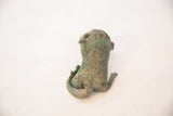 Overhead view of the vintage copper feline's back, showing spotted patina and curled tail.