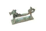 Vintage African copper dragon sculpture with a stylized body and green patina.