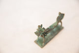 Head of a vintage African copper dragon showing detail of the snout and oxidized green patina.
