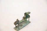 Angled view along the body of the vintage copper dragon, showing its green oxidized texture.