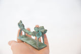 Vintage copper dragon sculpture held in hand to show its small scale and oxidized patina.