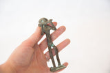 Vintage African copper collectible figurine held in hand for scale.