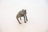 The textured, oxidized patina on the back of the vintage African copper boar sculpture.
