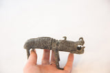 Vintage African copper boar held in hand, showing its compact size and dark, oxidized patina.