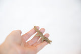 Vintage African crocodile pendant with a textured, oxidized bronze finish held in hand.