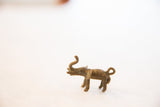 Side profile of a handmade bronze elephant pendant with an aged, oxidized texture.