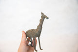 Angled view of the vintage copper giraffe's chubby form and textured, oxidized patina.