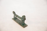 Side view of the vintage copper monkey highlighting its long body and oxidized finish.