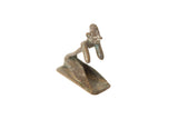 Vintage African oxidized copper person posing, showing a handmade quality and weathered patina.