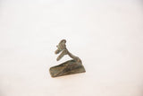 Profile of the oxidized African copper person revealing its sculpted form.