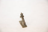 The textured, oxidized copper surface of the posing vintage person seen from behind.