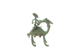 Vintage African oxidized copper sculpture of a stylized person riding an animal with a green patina.