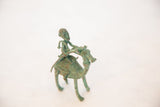 The green oxidized patina and handmade texture of an African copper sculpture.
