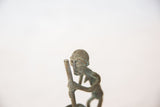 Expressive facial details and textured hair on the vintage African copper figurine.