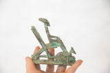 Vintage oxidized copper dog figure with textured base and greenish patina.