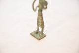 Detail of the textured, oxidized copper base and feet of the standing drummer.