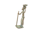 Vintage oxidized copper African figure walking with a staff, balancing an item on its head.