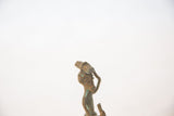 Close-up of the oxidized copper head and balanced bundle of a vintage African figure.