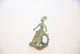 Side view of a vintage copper sitting woman showing its textured patina.