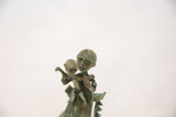Textured patinated copper faces of the handmade mother and child sculpture.