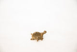 Side view of the vintage bronze turtle pendant's open mesh shell and textured patina.