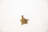 Angled view of the vintage bronze turtle pendant's mesh shell and hanging loop.