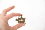 A hand holding the small vintage bronze turtle pendant to illustrate its scale.