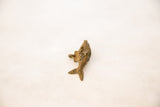 Vintage African bronze fish pendant, top-down view showing textured body and tail with mesh design.