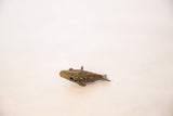 A vintage bronze fish pendant seen from a profile angle, highlighting its mesh design.