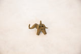African bronze elephant pendant with detailed handmade wire texture and aged patina, overhead view.