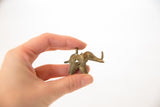Side profile of a vintage bronze elephant pendant with coiled wire texture.