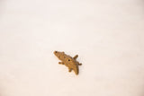 Angled view of the handmade bronze crocodile pendant showing its textured wire design.